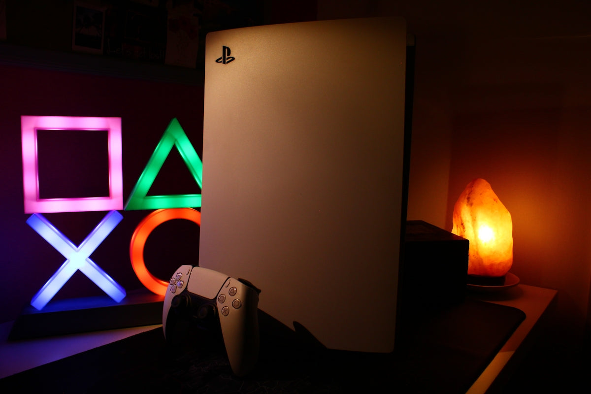 a video game console sitting next to a neon sign