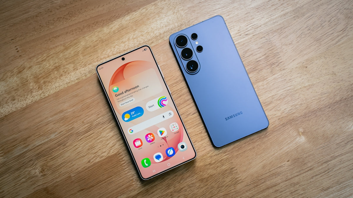 Two smartphones displayed on a wooden surface.